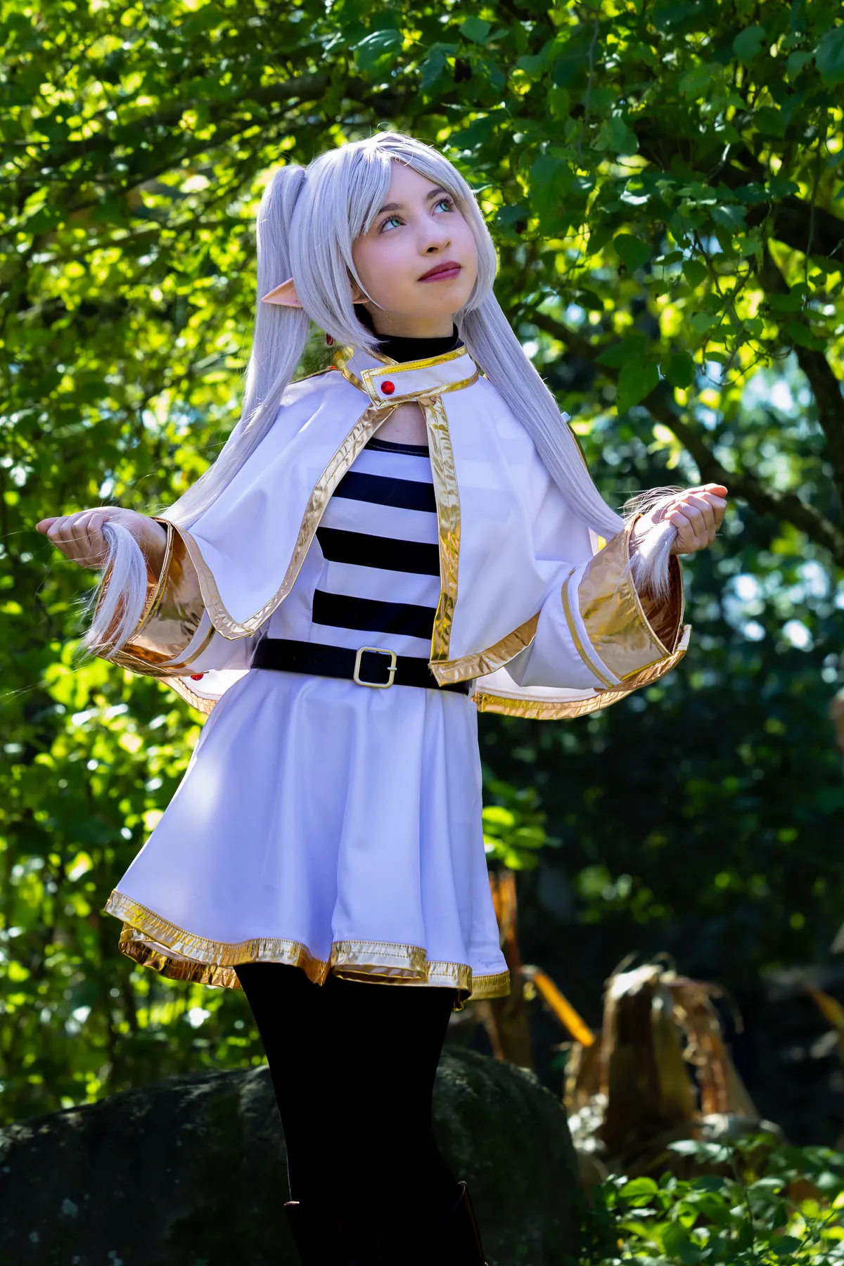 Cosplayer de roupa clara em meio à vegetação