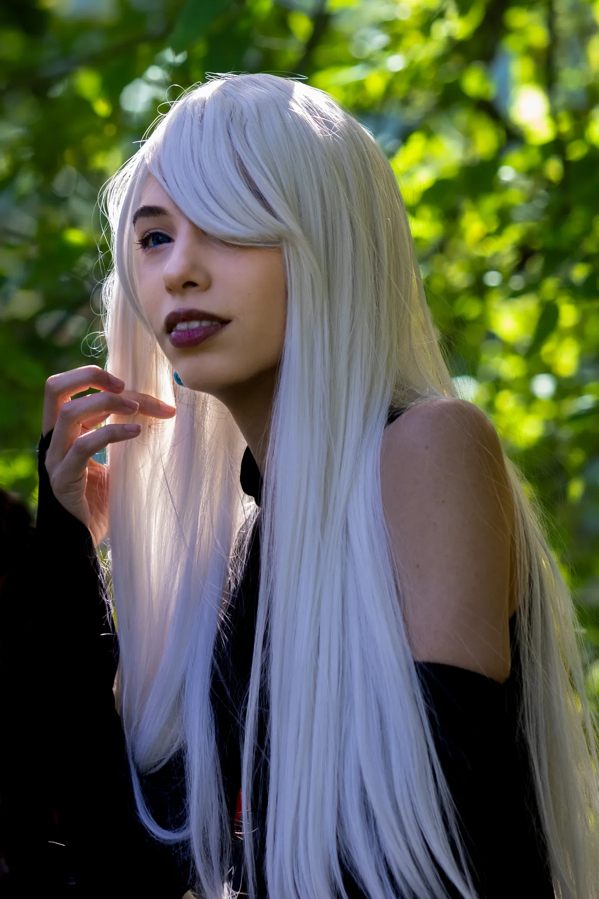 Retrato de cosplayer com peruca longa e branca entre árvores