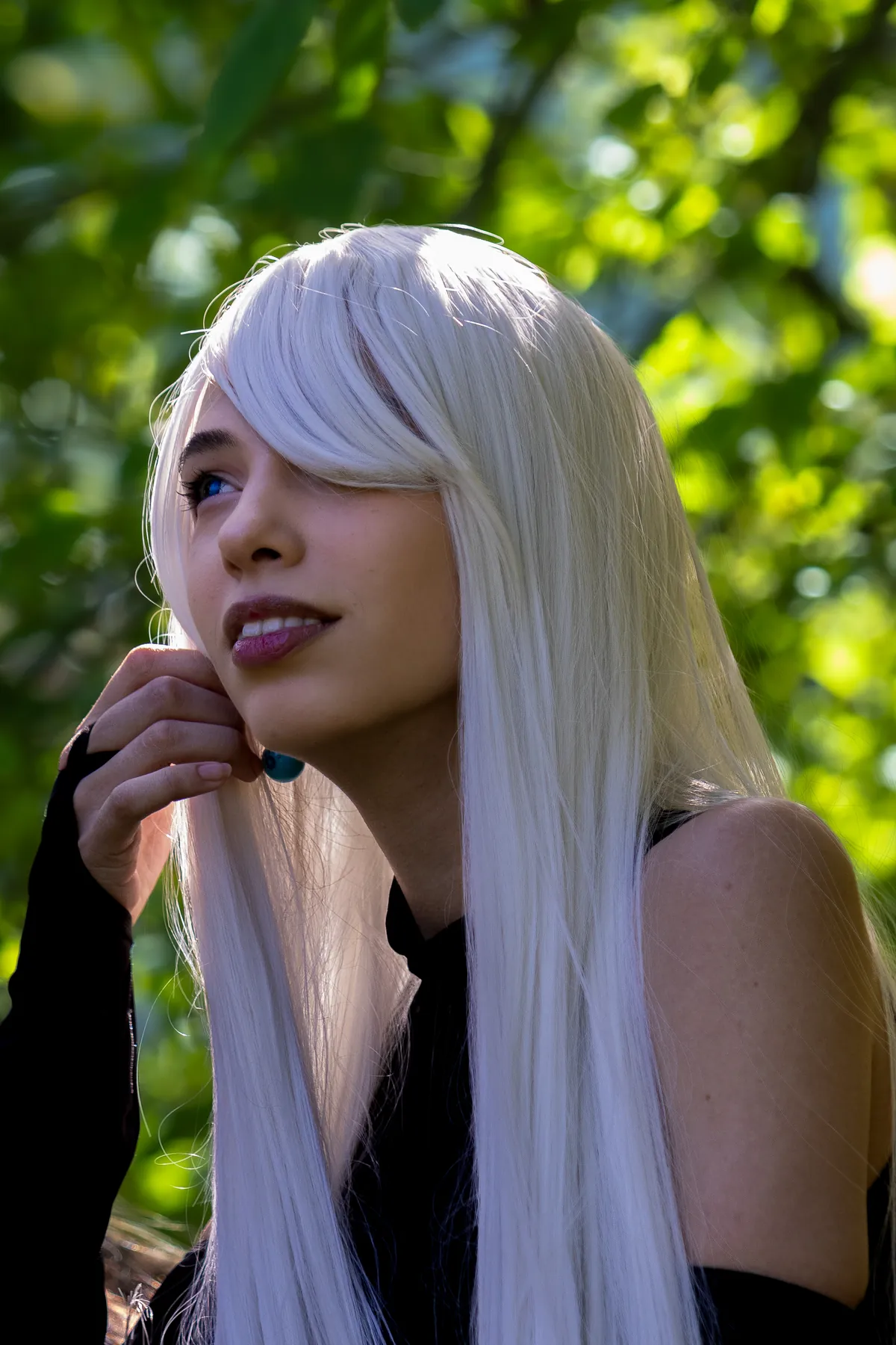 Cosplayer de cabelos brancos em roupa preta ao ar livre