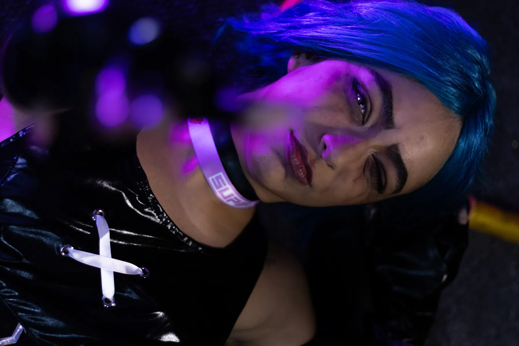 Retrato de cosplayer de cabelo azul sob iluminação roxa