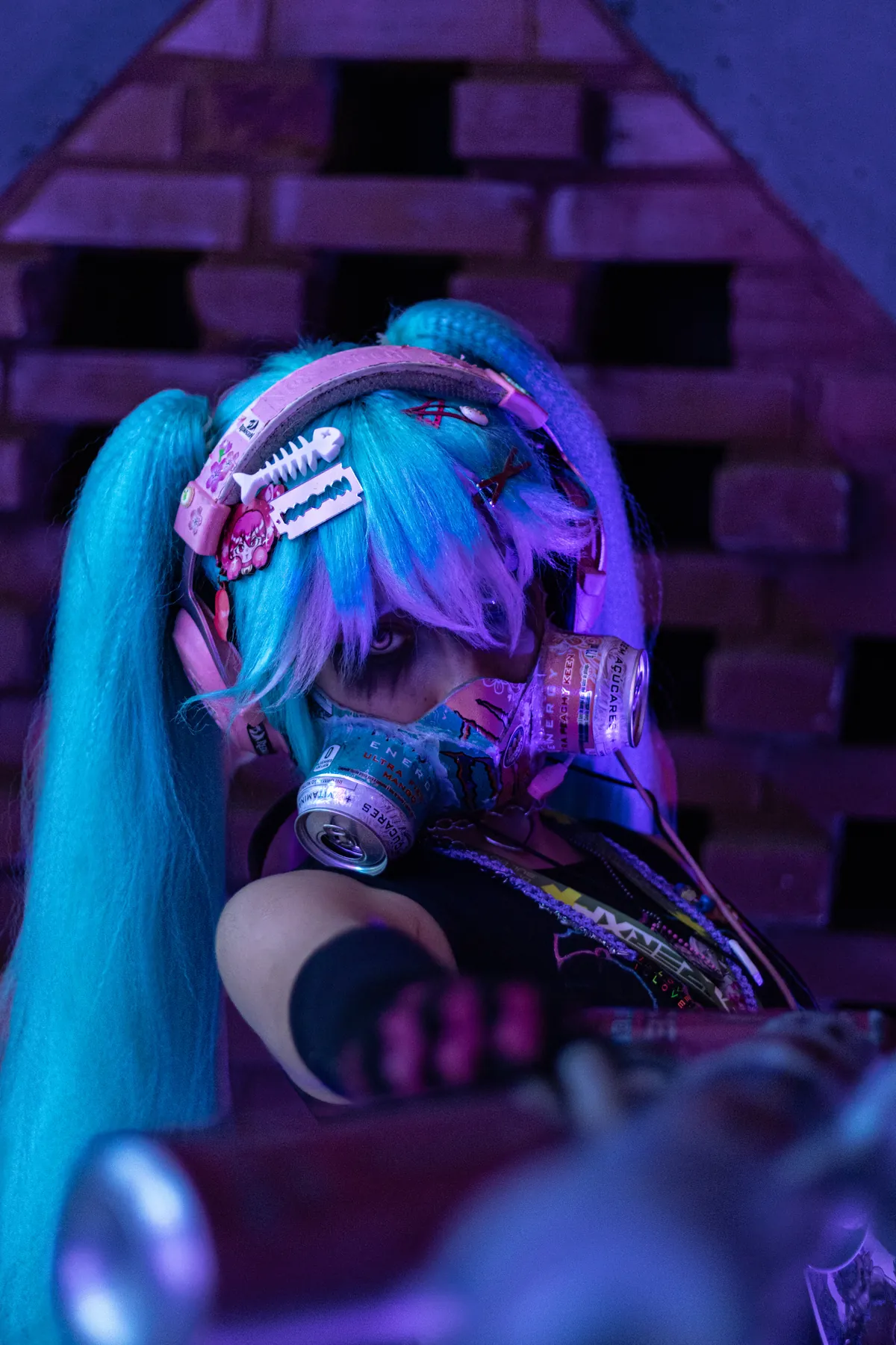 Cosplayer de cabelo azul posa com equipamento cenográfico